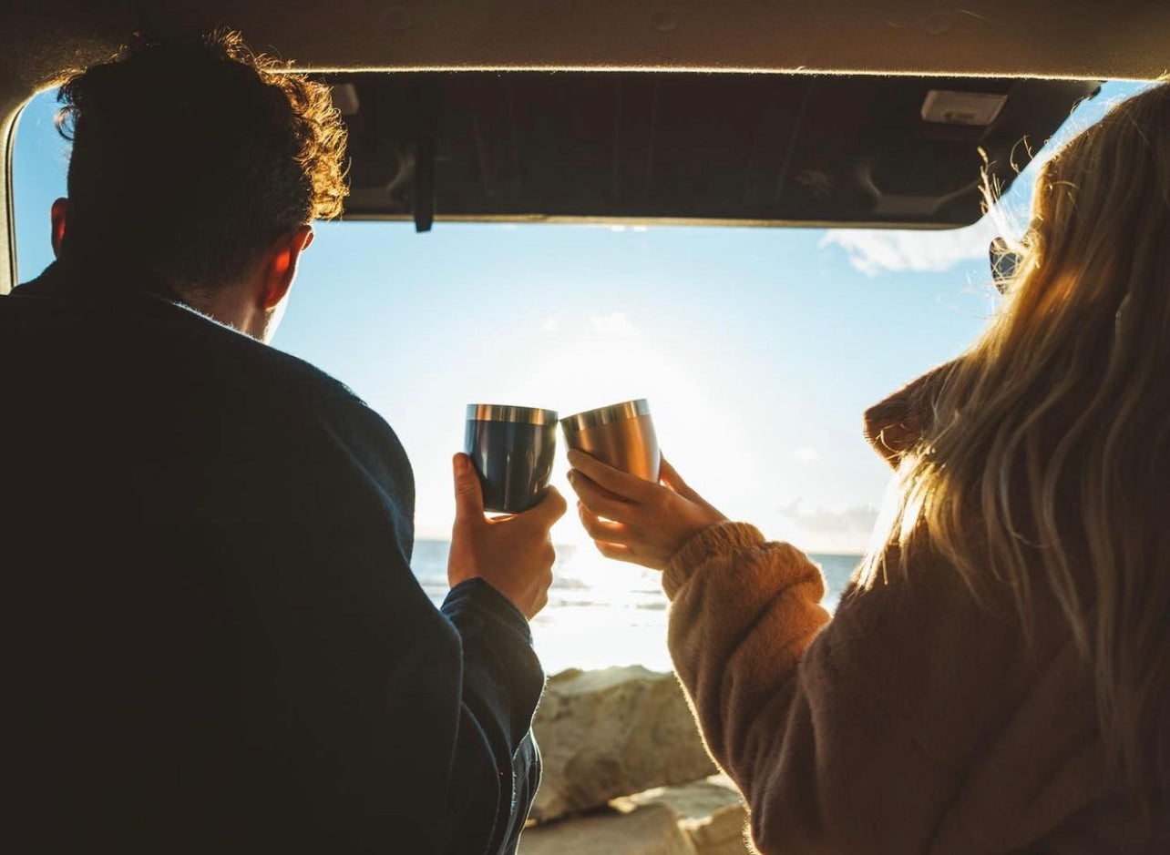 outdoors, cheers, camping trip, camping date, girl, boy, trunk of the car, ocean view date, ocean 